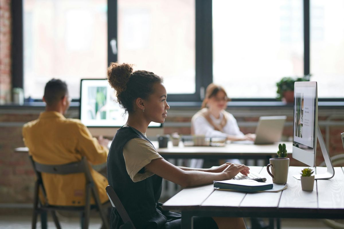 A tech professional working at a laptop in a modern office